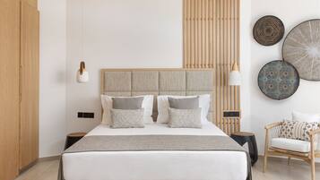A modern bedroom with a large bed, bedside tables, a chair, and decorative wall art.