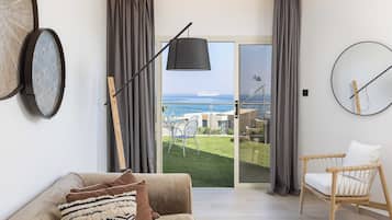 Suite junior, vista al mar | Área de sala de estar | Televisión de pantalla plana, tenis de mesa y libros