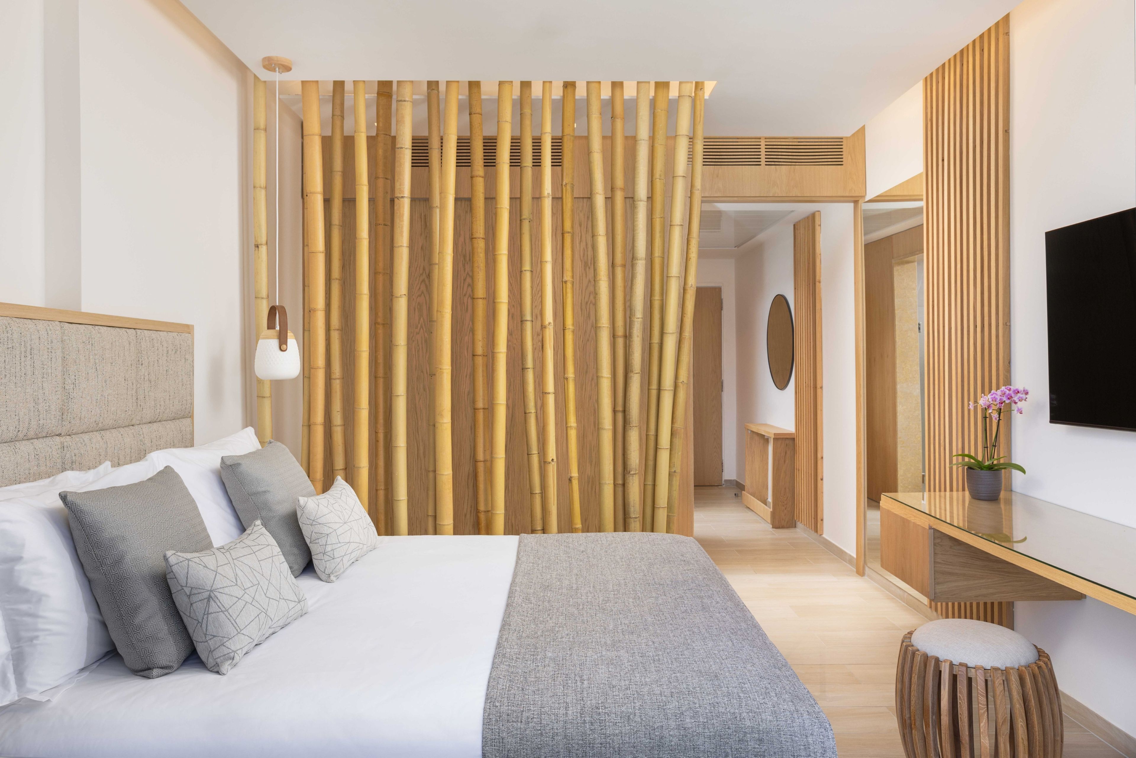 Une chambre à coucher moderne, avec un lit, des lampes de chevet, un bureau et un téléviseur.