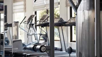 Un gimnasio con equipo de ejercicio, incluyendo cintas de correr y máquinas de pesas.