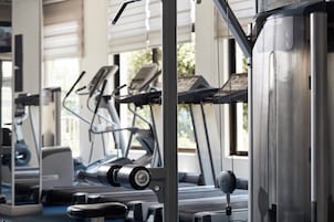 Un gimnasio con equipo de ejercicio, incluyendo cintas de correr y máquinas de pesas.