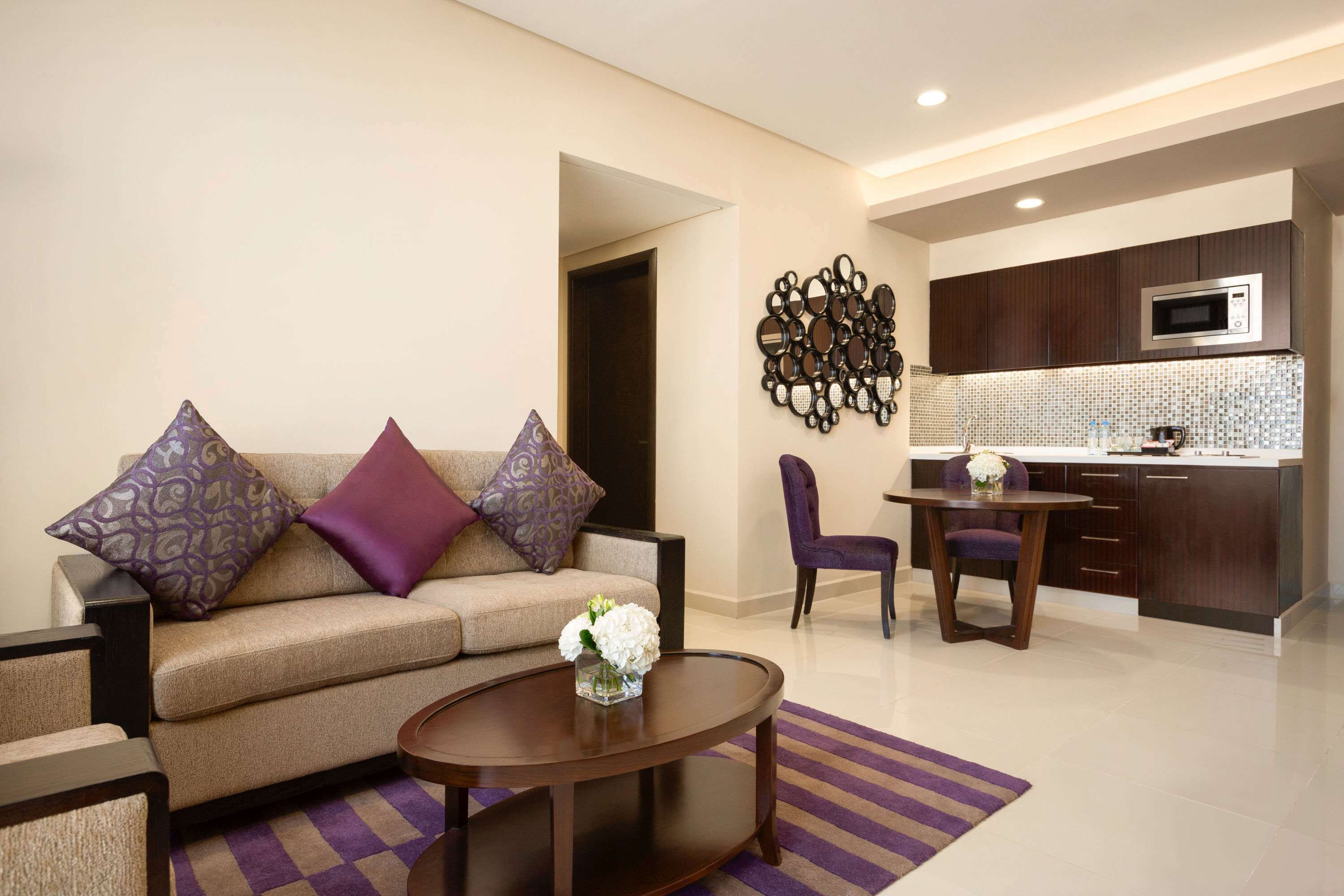 A modern living room with a sofa, coffee table, and a dining area with a chair and table.