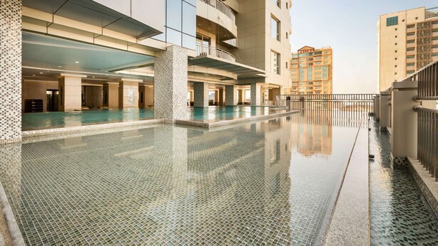Un hotel moderno con una grande piscina interna, diversi piani e balconi.