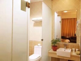 A bathroom with a toilet, sink, and mirror.
