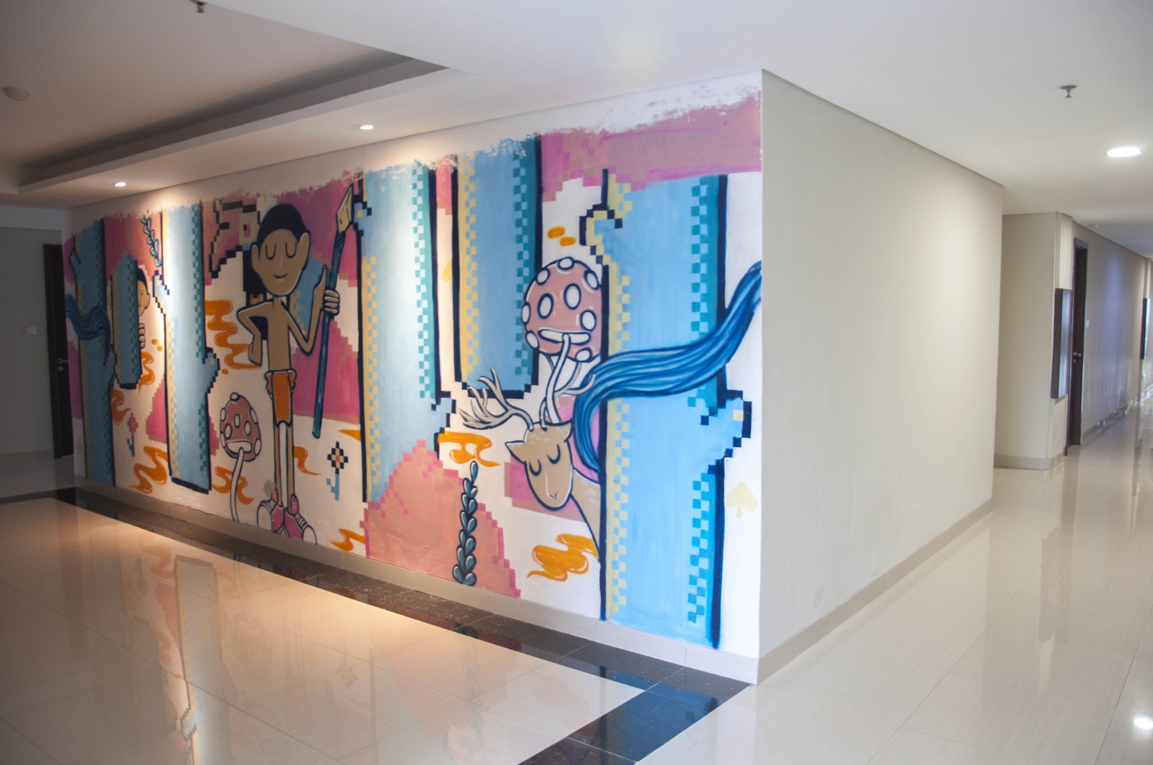 A hallway with a colorful mural featuring abstract figures and patterns.