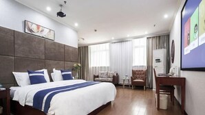 Una habitación de hotel moderna con una cama grande, un escritorio, una silla y un televisor.