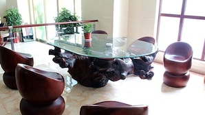 A dining area with a glass-top table surrounded by wooden chairs. - GreenTree Inn Liaocheng Town Dongchang Road Zhuanpan Business Hotel (Liaocheng)