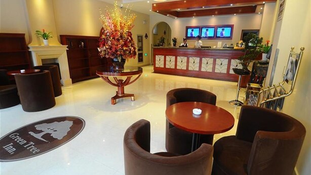 A lobby with a reception desk, a large floral arrangement, and seating area. - GreenTree Inn Huaian West Huaihai Road Hotel (Huai'an)
