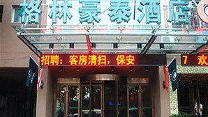 A hotel entrance with a glass canopy and a sign indicating room cleaning and security services. - GreenTree Inn Huaian West Huaihai Road Hotel (Huai'an)
