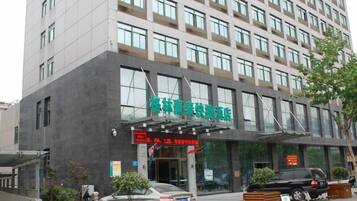 A modern hotel with a prominent entrance, large windows, and a sign indicating it offers PA, labor, and other services.