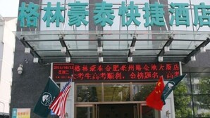 A hotel with a sign in Chinese characters, a digital display with red text, and flags hanging on the entrance. - GreenTree Inn Hefei Bozhou Road Jindi Building Hotel (Hefei)
