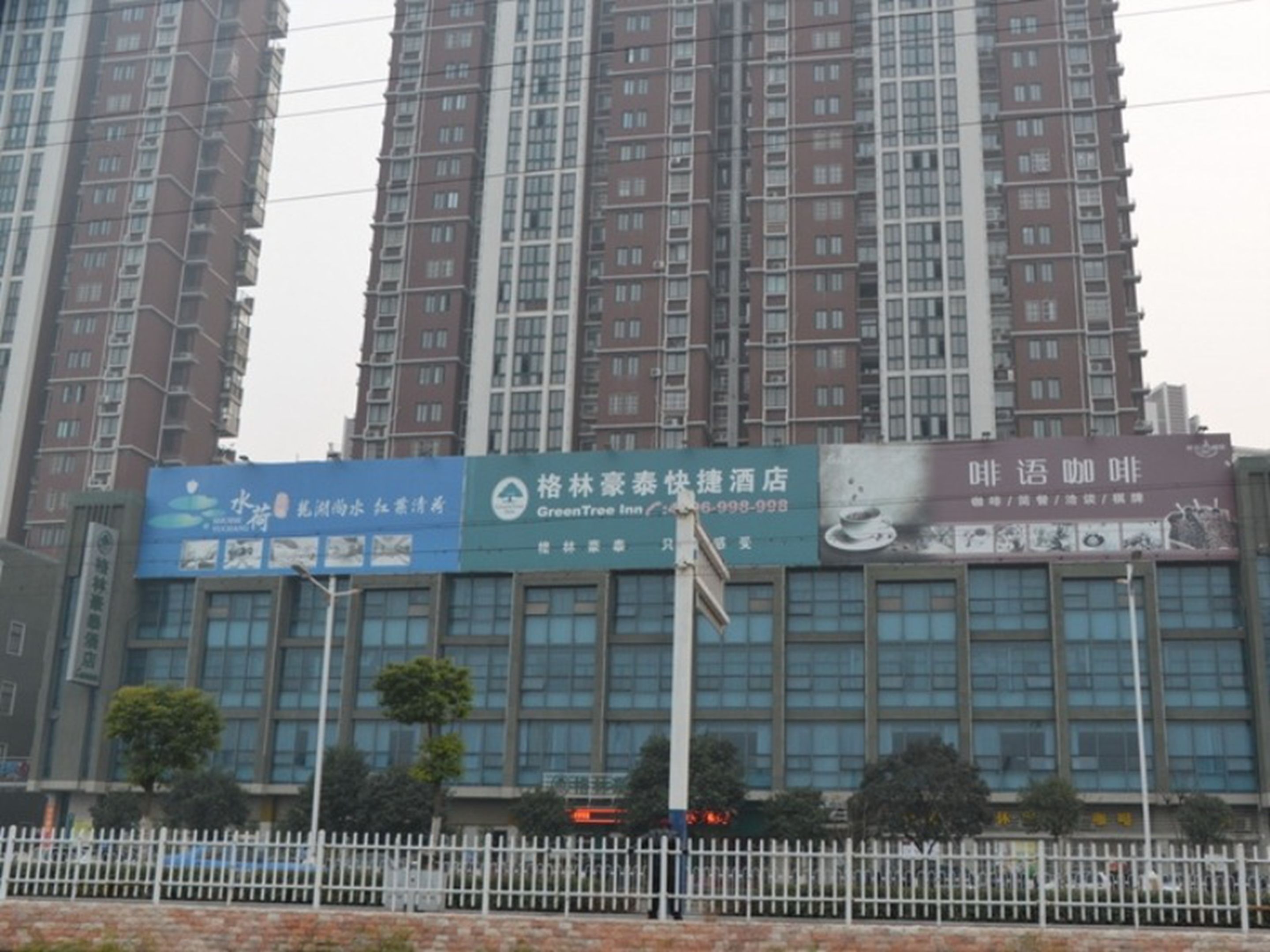 A multi-story building with several commercial establishments on the ground floor, including a hotel and a restaurant.