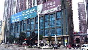 A multi-story building with large windows and a blue signboard. - GreenTree Inn Bengbu Longhu Express Hotel (Bengbu)