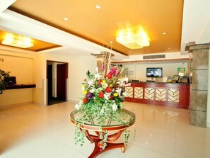 A hotel lobby with a reception desk, a large floral centerpiece on a glass table, and a modern chandelier. - Greentree Inn Nanjing China Gate Subway Station Express (Nanjing)