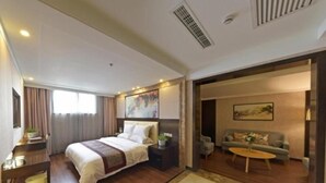 Une chambre d’hôtel comprenant un lit, une table de chevet et un coin salon avec un canapé et une table basse.