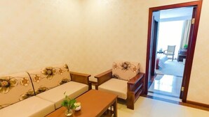 A living room with a sofa set, a coffee table, and a door leading to another room. - GreenTreeInn JiaDing F1Circuit FangTai HardwareMarket Hotel (Shanghai)