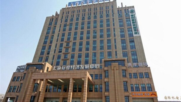 A tall, multi-story building with a prominent sign at the top. - GreenTreeInn JiaDing F1Circuit FangTai HardwareMarket Hotel (Shanghai)