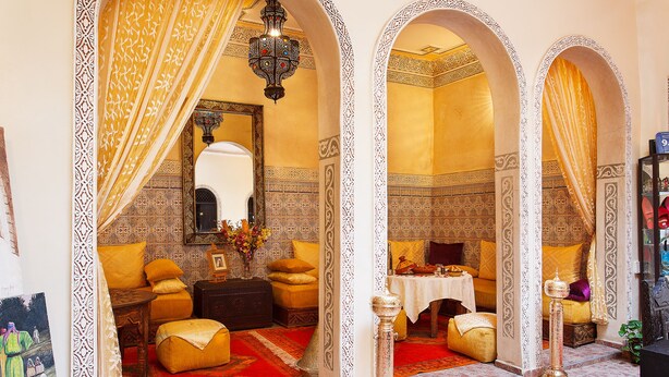 A traditional Moroccan room with ornate arches, a red carpet, and a decorative lamp. - Riad La Kahana (Marrakech)