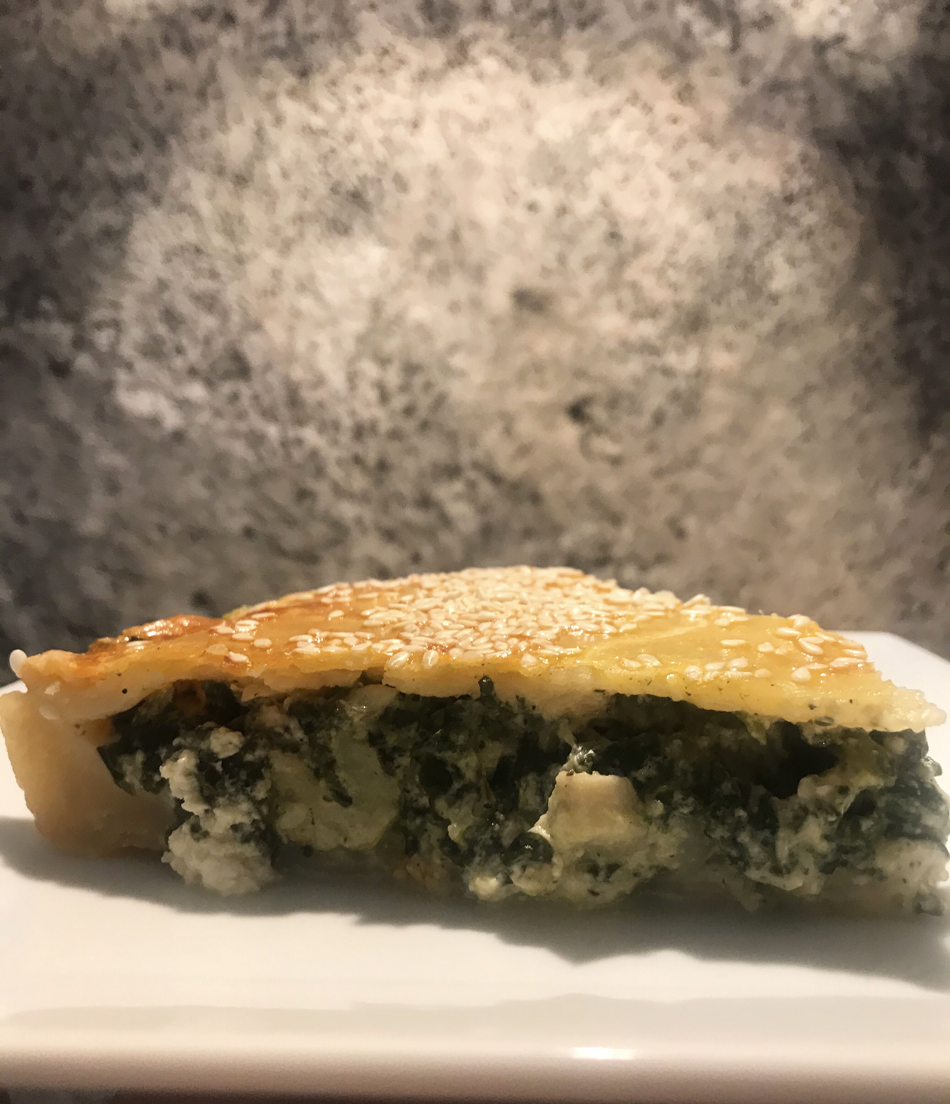 Una porción de pastel con corteza dorada y relleno cremoso, sobre un plato blanco.