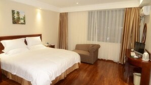 A hotel room with a bed, a desk with a computer, a chair, and a window with curtains. - GreenTree Inn Hefei Shushan District Guichi Road Express Hotel (Hefei)