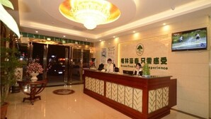 A hotel reception area with a modern design, featuring a reception desk, a chandelier, and a television screen displaying a sports event. - GreenTree Inn Hefei Shushan District Guichi Road Express Hotel (Hefei)