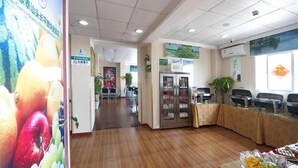 A hotel lobby with a reception desk, seating area, and a refrigerator. - Greentree Inn Guangdong Shantou Changping Road Exp (Shantou)