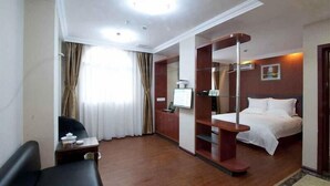 A hotel room with a bed, a desk, a chair, a TV, and a wardrobe. - Greentree Inn Guangdong Shantou Changping Road Exp (Shantou)