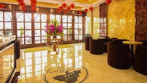 A lobby with a marble floor, a reception desk, and red lanterns hanging from the ceiling.