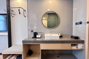 A modern bathroom with a marble countertop, a round mirror, a sink, and a towel rack. - GreenTree Inn Fuyang Shopping Mall (Bozhou)