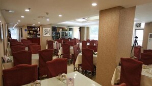 Een restaurant met meerdere tafels en stoelen, waarvan sommige zijn gedekt.