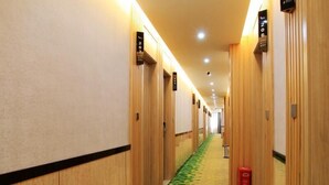 A hotel hallway with wooden doors, numbered room signs, and a patterned carpet. - Vatica Fuzhou West Second Ring Road Xihu Park Hote (Fuzhou)