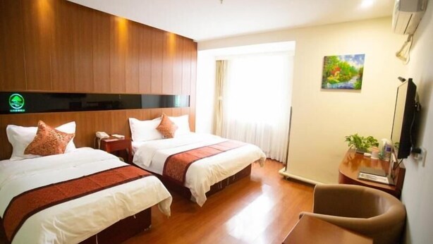 A hotel room with two beds, wooden flooring, a desk with a chair, a painting on the wall, and a window with curtains. - GreenTree Inn TianJin Ji County South YuYang Road GuLou Square Express Hotel (Tianjin)