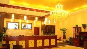 A hotel lobby with a reception desk, two televisions, a chandelier, and potted plants. - GreenTree Inn TianJin Ji County South YuYang Road GuLou Square Express Hotel (Tianjin)