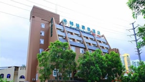 A hotel with a modern architectural design, featuring a prominent vertical structure and multiple balconies. - GreenTree Inn Haikou Longhua District Guomao Hotel (Haikou)