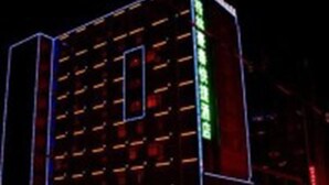 A multi-story hotel building with illuminated signage and a modern architectural design.