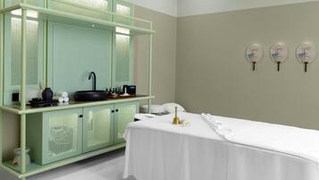 Relax in a serene space with a central massage table, green cabinet, and decorative accents.