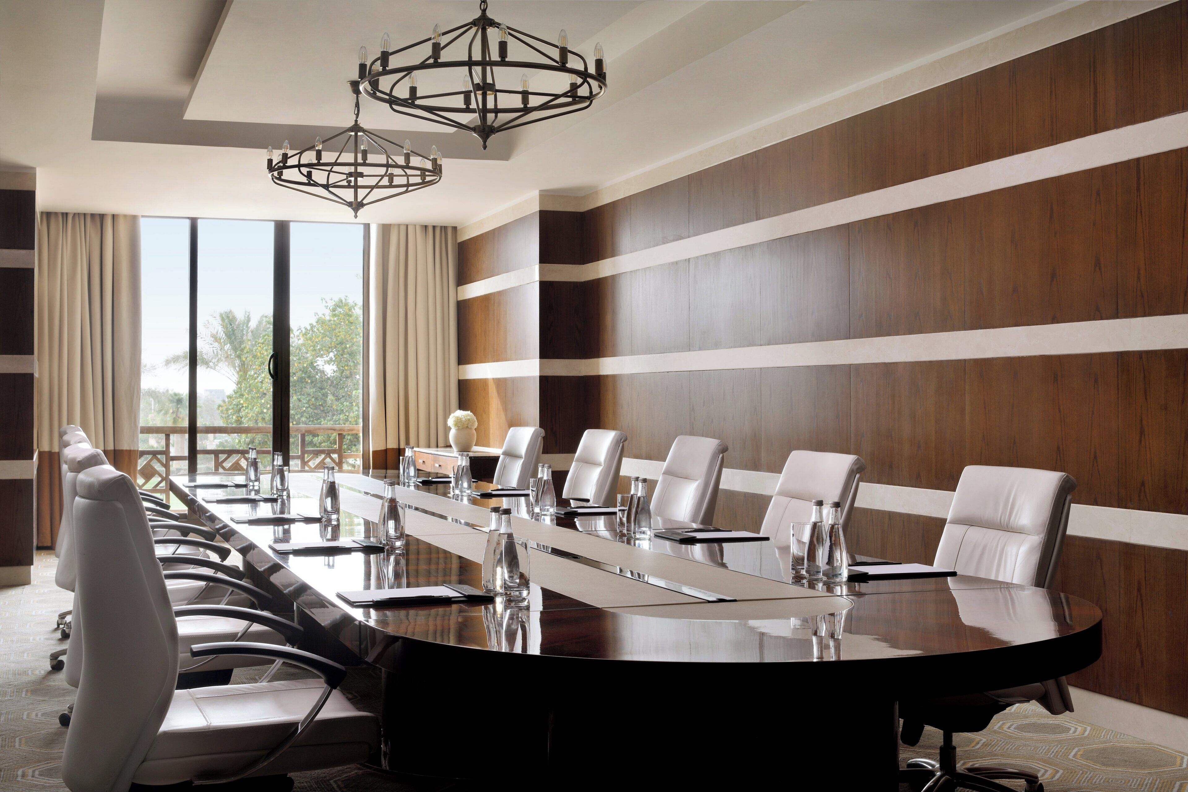 A conference room with a long table, multiple chairs, and a chandelier.