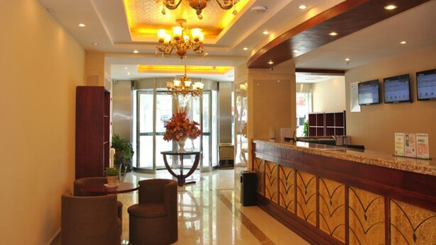 A hotel lobby with a reception desk, a chandelier, and a seating area with two chairs. - GreenTree Inn SuZhou LingBi County Middle JieFang Road Express Hotel (Suzhou)