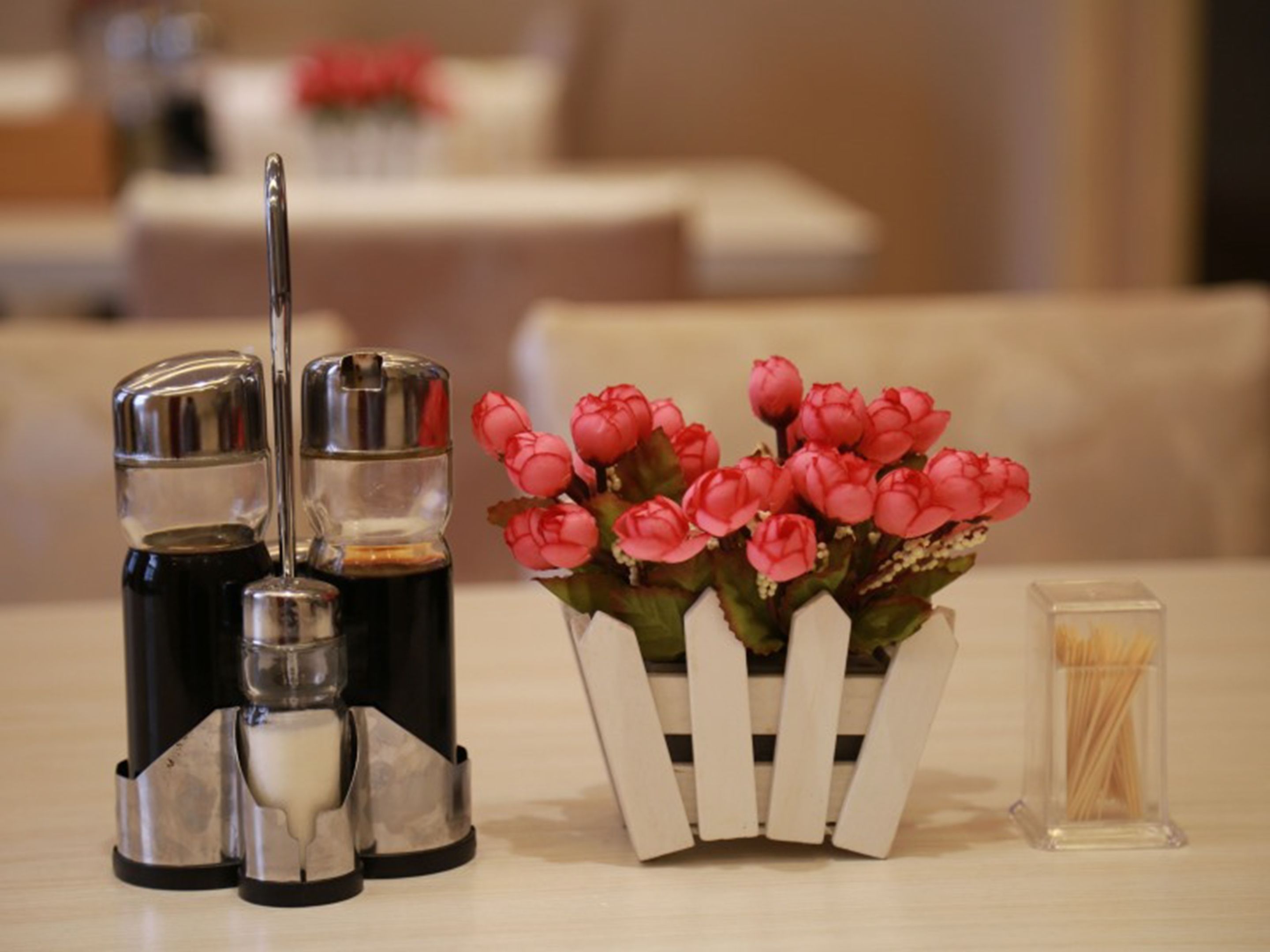 Une table avec des salières et des poivrières, un arrangement floral et un récipient rempli de cure-dents.
