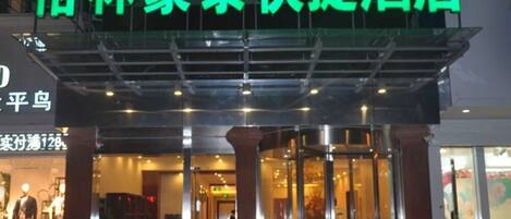 A hotel entrance with a glass door and a sign above it.