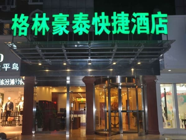 A hotel entrance with a glass door and a sign above it.