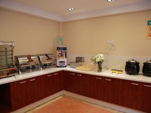 A kitchen with a coffee machine, a toaster, a kettle, and a rice cooker.