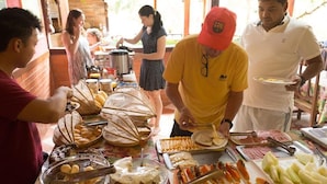 Un buffet proposant une variété de plats, notamment du pain, des pâtisseries et des viandes en tranches.