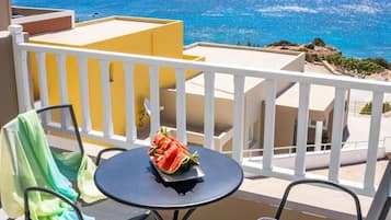 Un balcone con tavolo, sedie e vista sul mare.