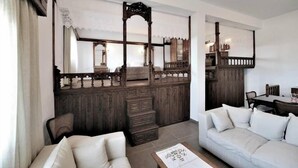 Quarto tradicional com guarda-roupa de madeira, um sofá e uma mesa de jantar.