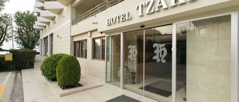 A modern hotel facade with a prominent sign reading "HOTEL TZAKI".