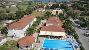 A hotel with a swimming pool, multiple buildings, and a view of the sea. - Hotel Metaxa (Zakynthos)