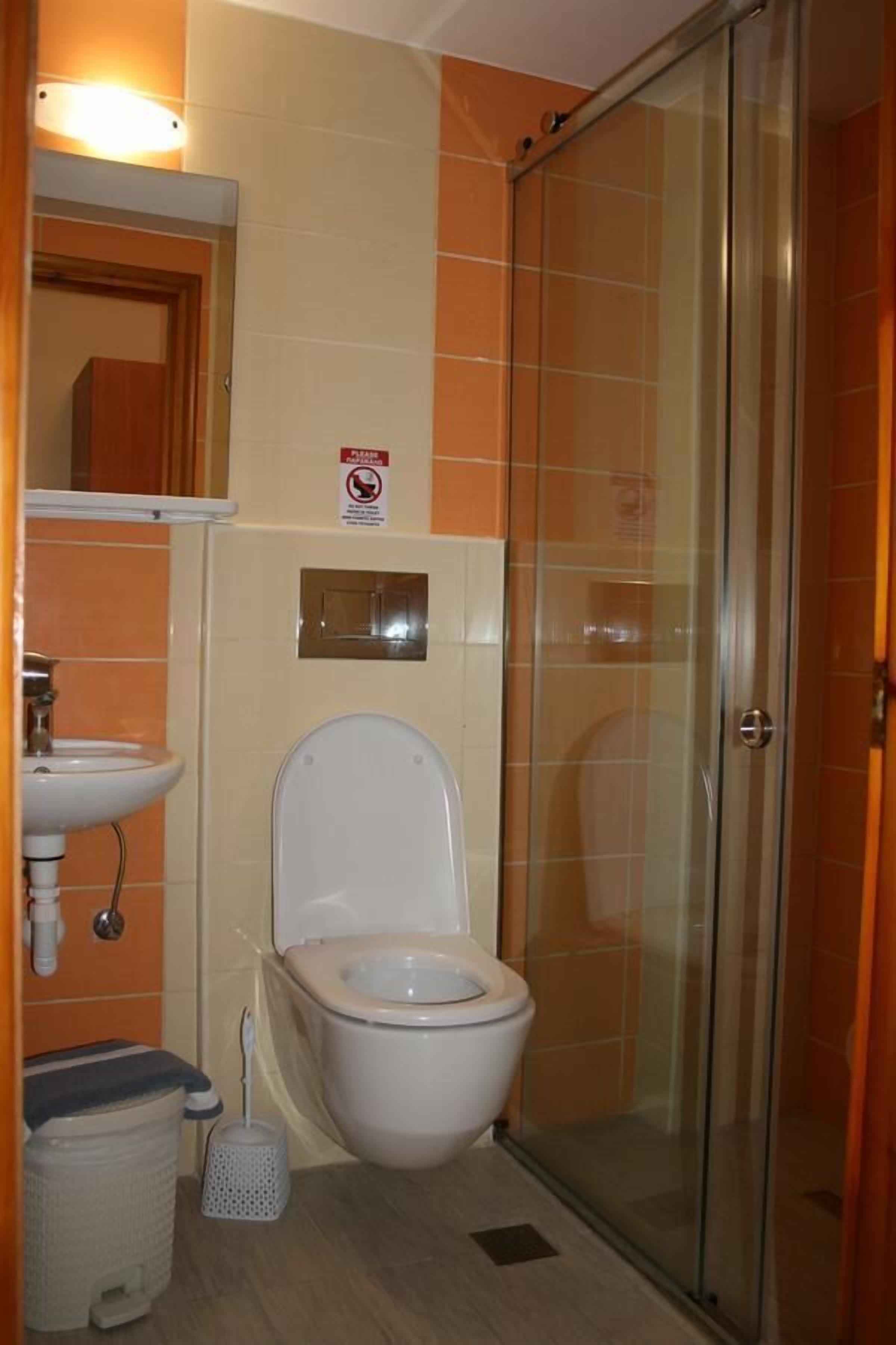 A bathroom with a toilet, sink, and shower.