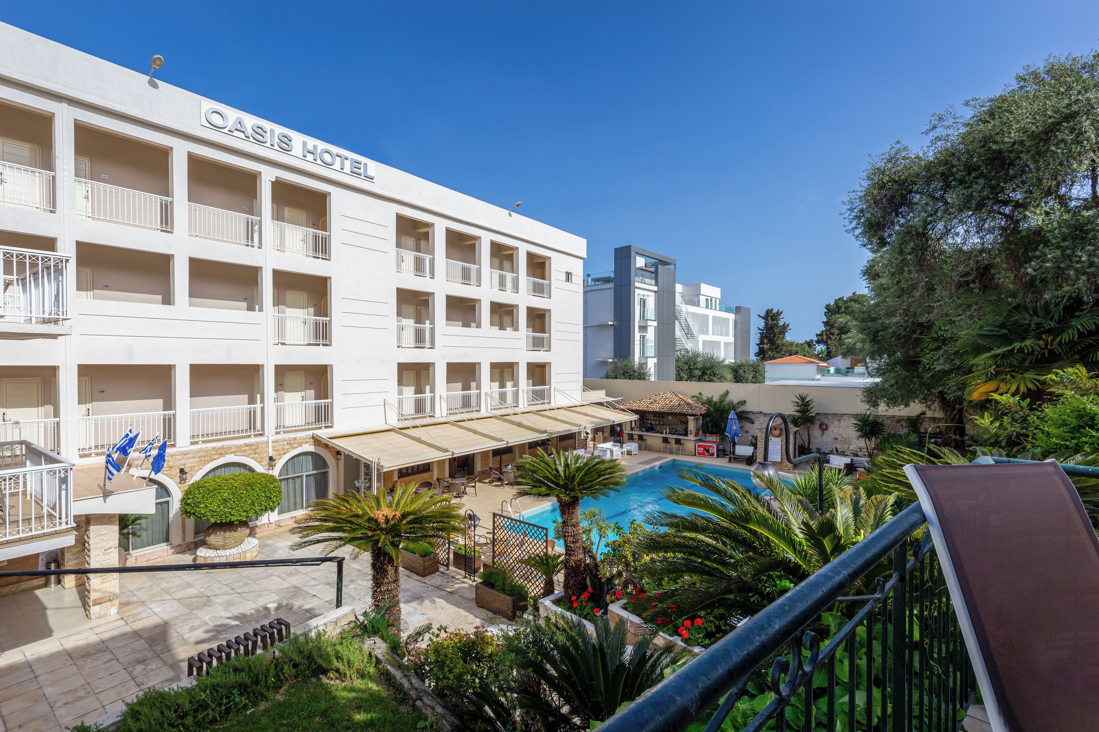 Un hotel con varios balcones, piscina y zonas de estar al aire libre.