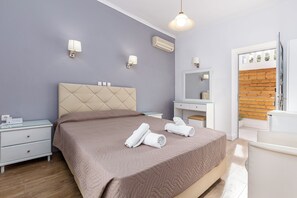 Un dormitorio moderno con cama, mesitas de noche, cómoda y espejo.